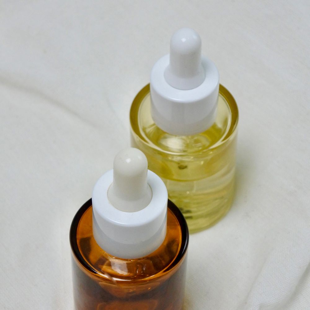 Frascos de aceite capilar sobre tejido claro