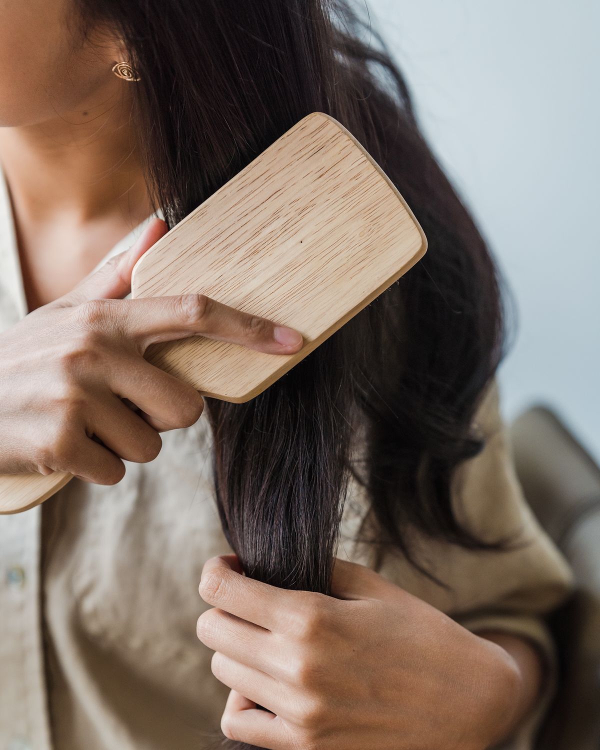 Mujer cepillando su melena larga con un cepillo de madera