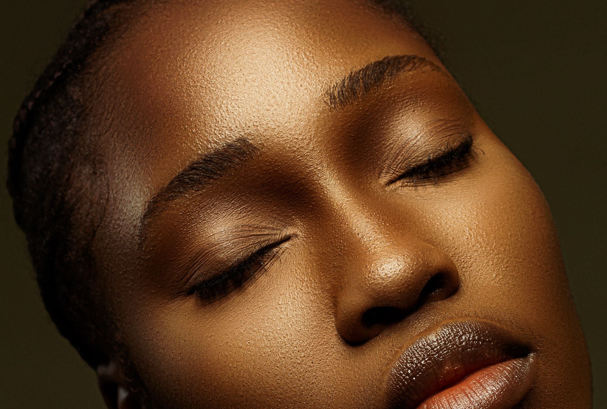Primer plano de una mujer con la piel luminosa y los ojos cerrados